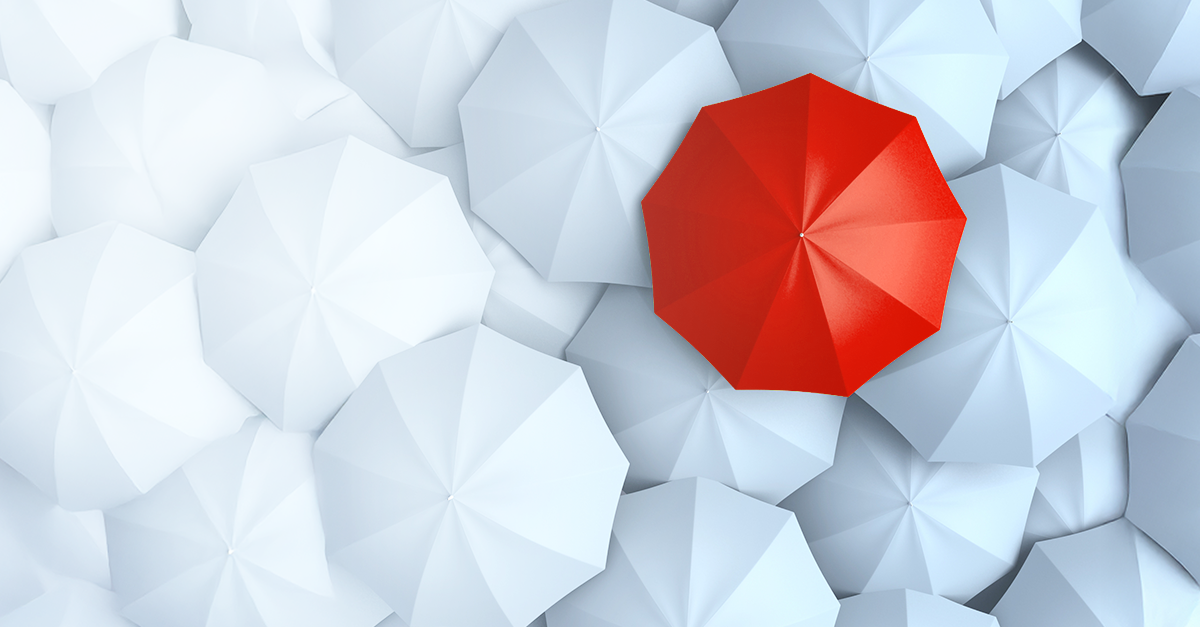A red umbrella standing out among white umbrellas